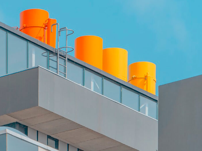 Vista de tejado de fábrica con chimeneas en tonos naranja